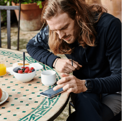 Mann wertet am Handy ein Training aus