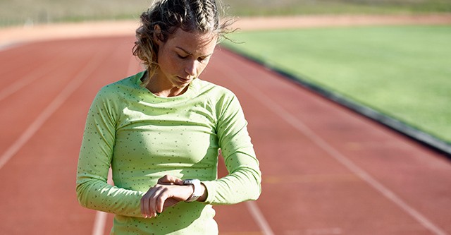 Läuferin kontrolliert ihre Trainingsdaten mit einer Polar Sportuhr