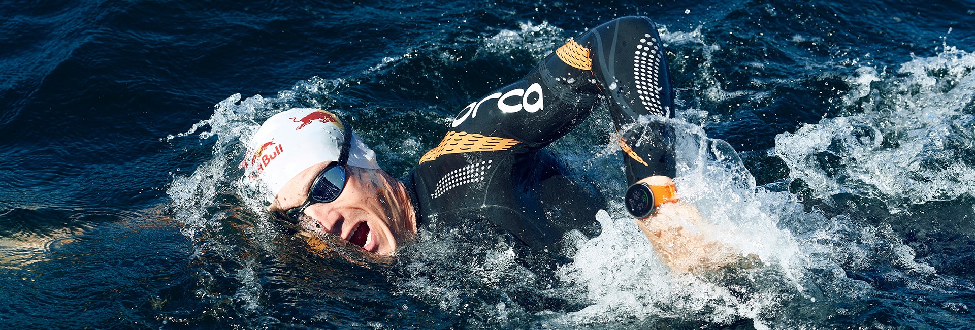 Mann schwimmt in freiem Gewässer - Training zum ersten Triathlon