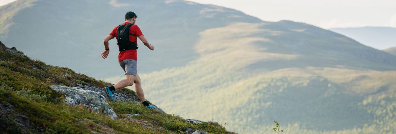 Mann läuft auf einem Trail in den Bergen /die besten Trail-Apps