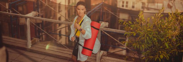 Frau mit Yogamatte - Wiedereinstieg nach Trainingspause